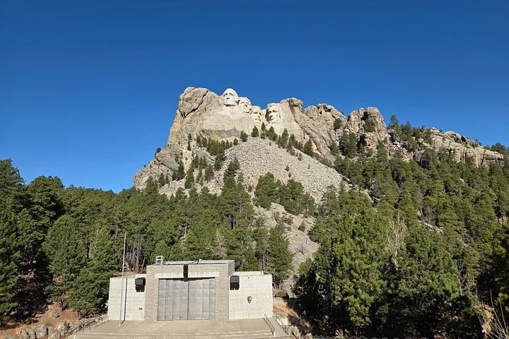 Weitblick auf das Mount Rushmore Memorial und ein Betongebäude darunter