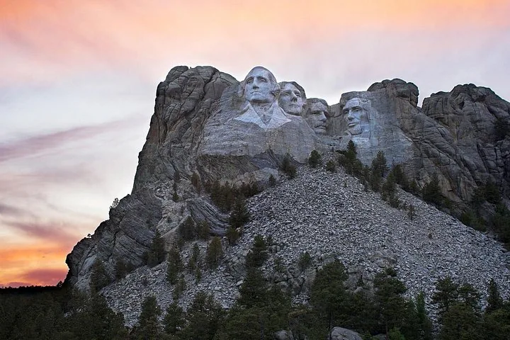 Das beleuchtete Mount Rushmore National Memorial vor einem Abendhimmel